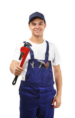 Young handsome plumber with tools on white background