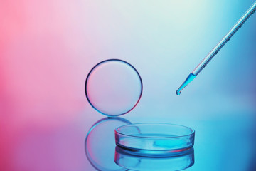 Chemical glassware with medicine dropper on color background