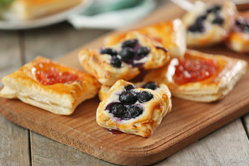 Sweet tasty pastries on cutting board, closeup