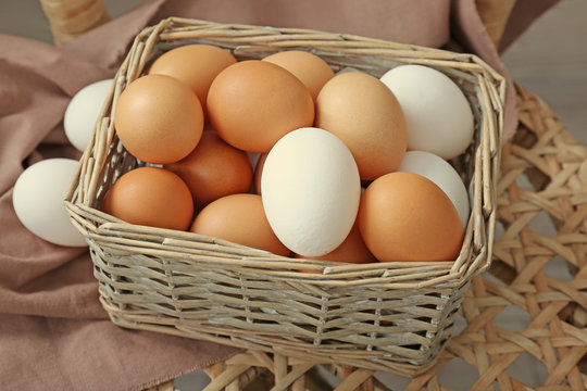 Raw eggs in wicker basket, closeup