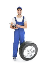 Young mechanic in uniform with a clipboard on white background