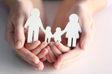 Child and adult person holding figure in shape of happy family, closeup. Adoption concept - obrazy, fototapety, plakaty