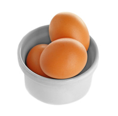 Raw eggs in bowl on white background