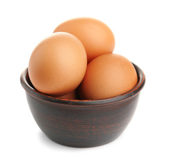 Raw eggs in bowl on white background