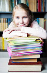Beautiful smiling student with pile of books
