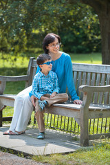 Fototapeta premium Mother and her little son sitting on a bench
