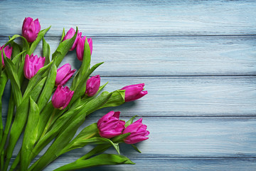 Purple beautiful tulips on wooden background