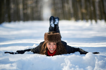 Fototapeta na wymiar Young woman lying in the snow