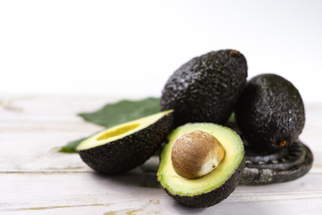 Green ripe avocado with leaves close up