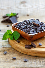 Dark chocolate drops in a wooden bowl.