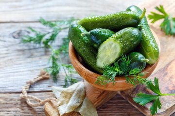Salted cucumber and dill in a wooden bowl.