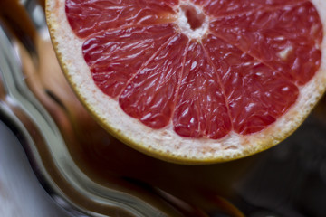 a composition of grey fruits and oranges served on a chromed metallic tray with an old silver knife and fork wrapped into a handkerchief on a light wooden background.