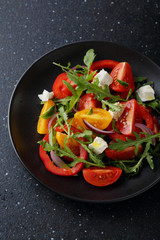 Fototapeta na wymiar Tomato salad with arugula and cheese