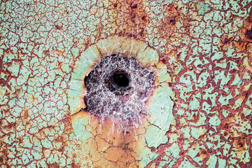 Cobweb in a hole in old rusty cracked metal background