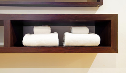 white towels on wooden shelf