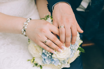 Obraz na płótnie Canvas hands of bride and groom with bouquet