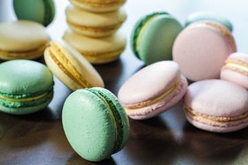 Freshly made pink, green and yellow french macarons on the tabke