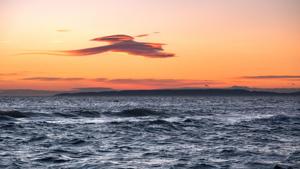 Fototapeta na wymiar un nuage en forme d'oiseau au dessus de la mer au coucher de soleil