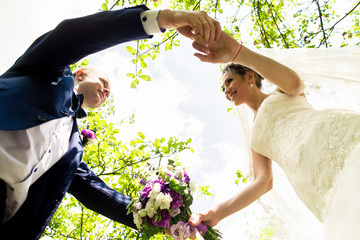 Bride and groom in a park kissing.