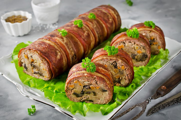 Oven baked meatloaf with bacon on a concrete grey background