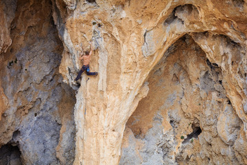 Rock climber on challenging route on cliff