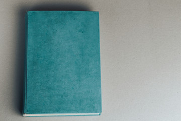 Blank old book on grey to replace your design. Top view.