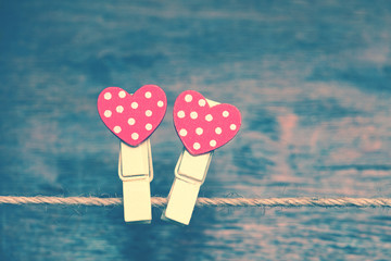 Two red heart on a background of wood. Creative heart - clothespins hanging on a rope. The Valentine's Day Holiday. Romantic photo in vintage style