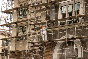 Men in hardhats and safety vests working on a large construction project on a cloudy winter day 