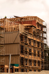 Men in hardhats and safety vests working on a large construction project on a cloudy winter day 