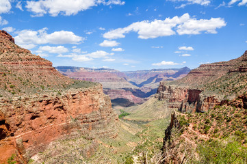 Fototapeta na wymiar Stunning view of Grand Canyon National Park in Arizona, USA. Sunny day with clouds. Grand Canyon a gorge of the Colorado River, which is considered one of the Seven Natural Wonders of the World.