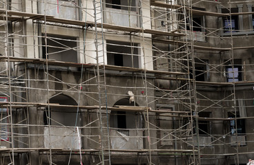 Men in hardhats and safety vests working on a large construction project on a cloudy winter day 