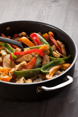 Chicken fajitas with lettuce and tomatoes filling in a skillet