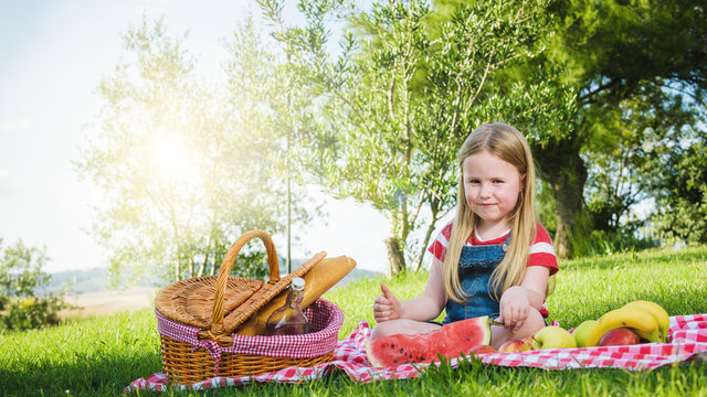 Small beautiful blond girl doing picnic in the landscape of Tusc