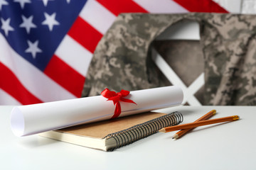 Notebook, diploma and pencils on white table. USA military education concept