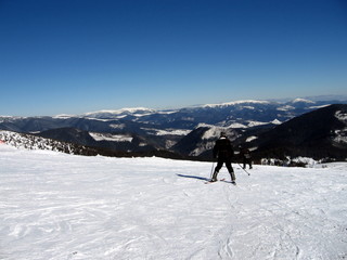 Skiers ride the mountain, rear view