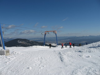 Group of skiers rose in the ski-lift to the top of the mountain