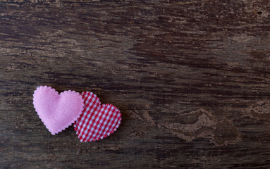 Two pink hearts placed on the old wooden floor.