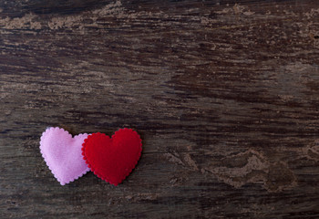 Pink and red hearts placed on the old wooden floor.