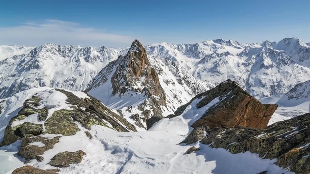Beautiful Sunny Winter Day in Snowy Alps Mountains.Time Lapse Dolly Shot over Snowy Rocks and Majestic Peaks
