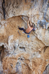 Rock climber on challenging route on cliff