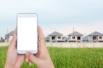 Hand holding smart phone, looking for a new houses in suburb.