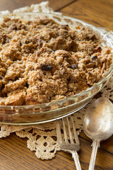Fresh homemade dutch apple crumb dessert pie on doily with utensils