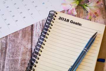 Naklejka premium 2018 Goals motivational concept with notebook and pen on wooden board 