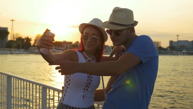 Couple taking selfie at sunset on a pontoon