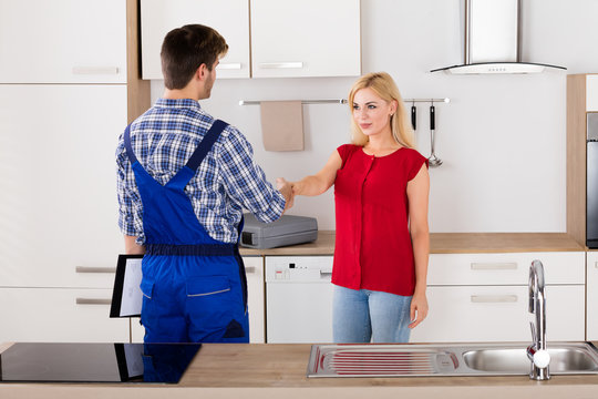 Woman Shaking Hands With Male Plumber