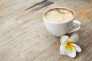 Coffee with milk and white frangipani flower