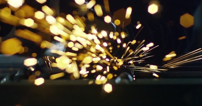 locksmith with a laser cuts in half a sheet of steel causing sparks.The laser heat Nicks iron up to get clean cuts and perfect for buildings with wrought iron.Concept: industry,technology,engineering.