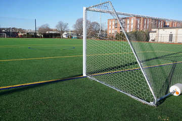 sport field in residential area with artificial green grass and football goal