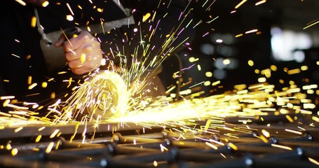 locksmith with a laser cuts in half a sheet of steel causing sparks.The laser heat Nicks iron up to get clean cuts and perfect for buildings with wrought iron.Concept: industry,technology,engineering.