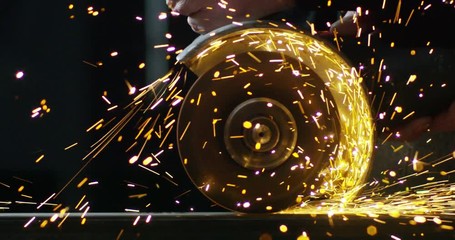 locksmith with a laser cuts in half a sheet of steel causing sparks.The laser heat Nicks iron up to get clean cuts and perfect for buildings with wrought iron.Concept: industry,technology,engineering.